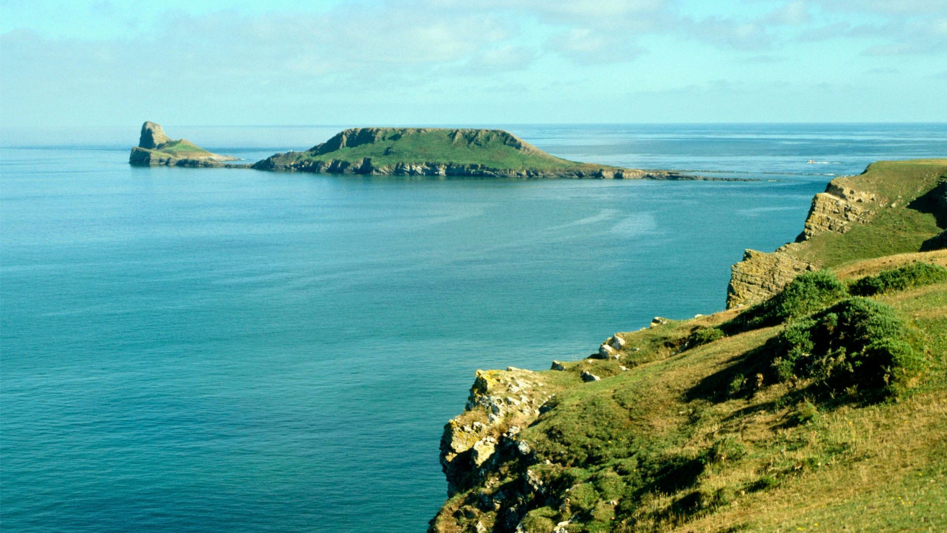 Gower Peninsula coastline with cliffs and blue sea, a destination for kayaking in South Wales