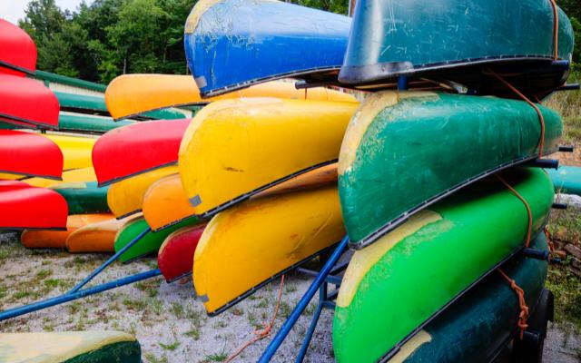 Colourful open canoes stored upside down on racks