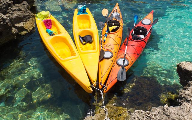 Sit-on-top and closed-cockpit kayaks together on clear water