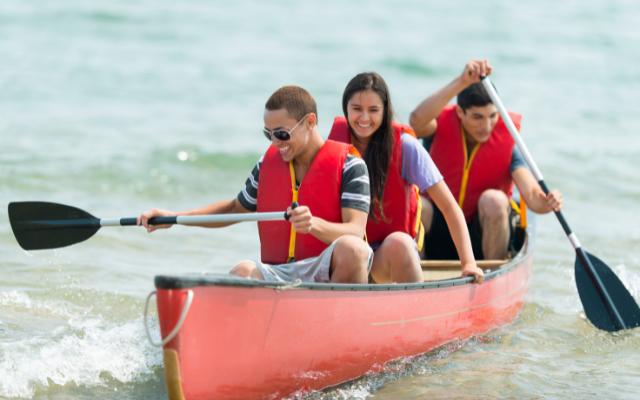 Three people travelling in an open canoe