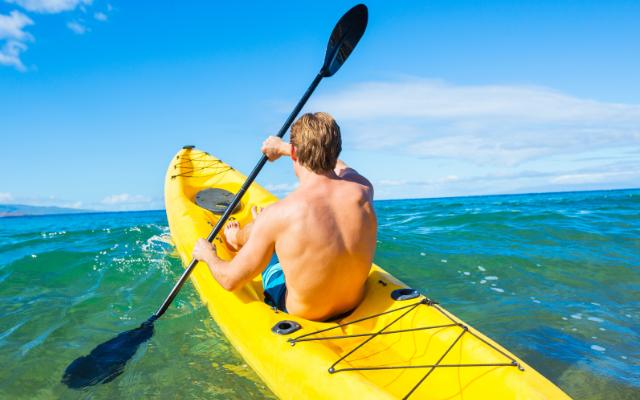 A paddler in a yellow kayak on the sea