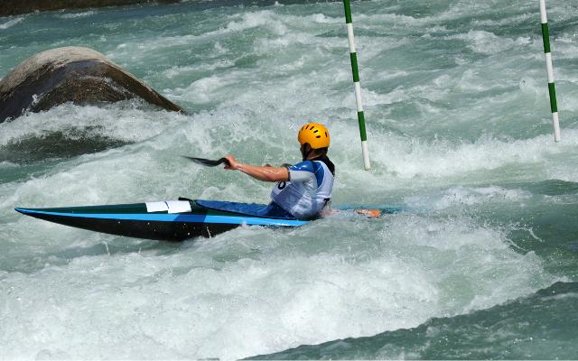 A kayaker passing a slalom gate in white water