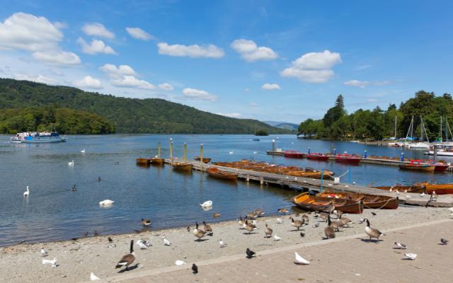 Rowing boats, jetties and swans on Windermere at Bowness