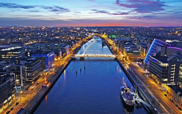 The River Liffey and illuminated bridges through central Dublin at dusk