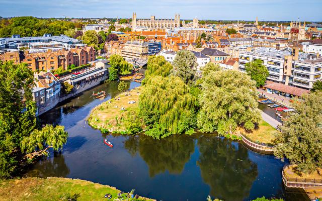 Aerial view of riverside buildings and a tree-lined island