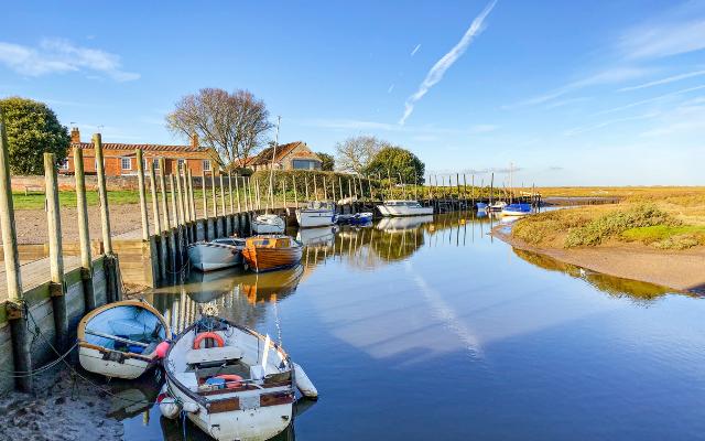 Small boats moored beside the quay at Blakeney harbour