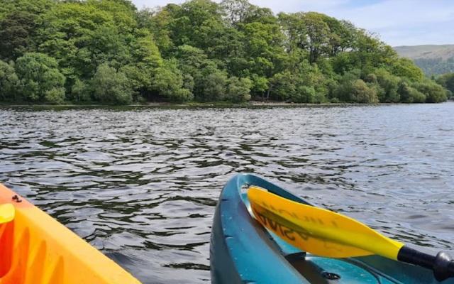 Two kayaks beside a wooded island on Derwentwater