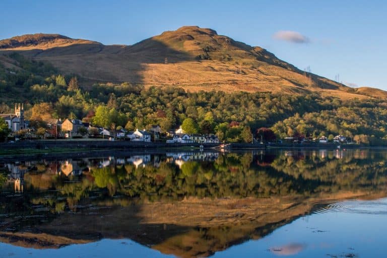 Tarbet village and autumn hills reflected in the still waters of Loch Lomond