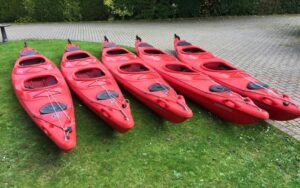 Red kayaks arranged on grass