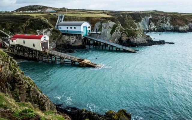Lifeboat houses and slipways above a rocky cove
